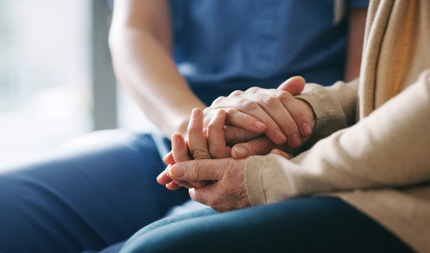 Caregiver holding patient's hands